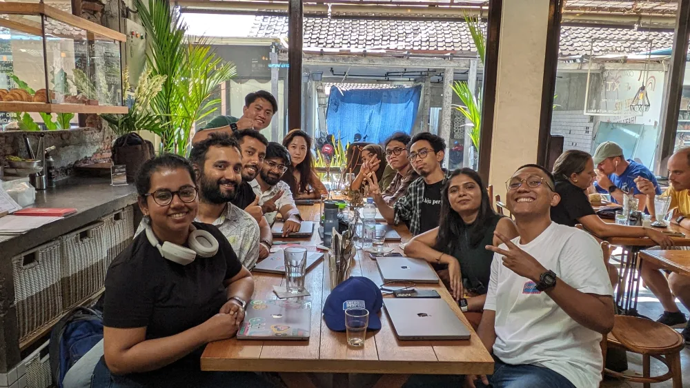 The Jiva team gathered around a table with laptops in Bali